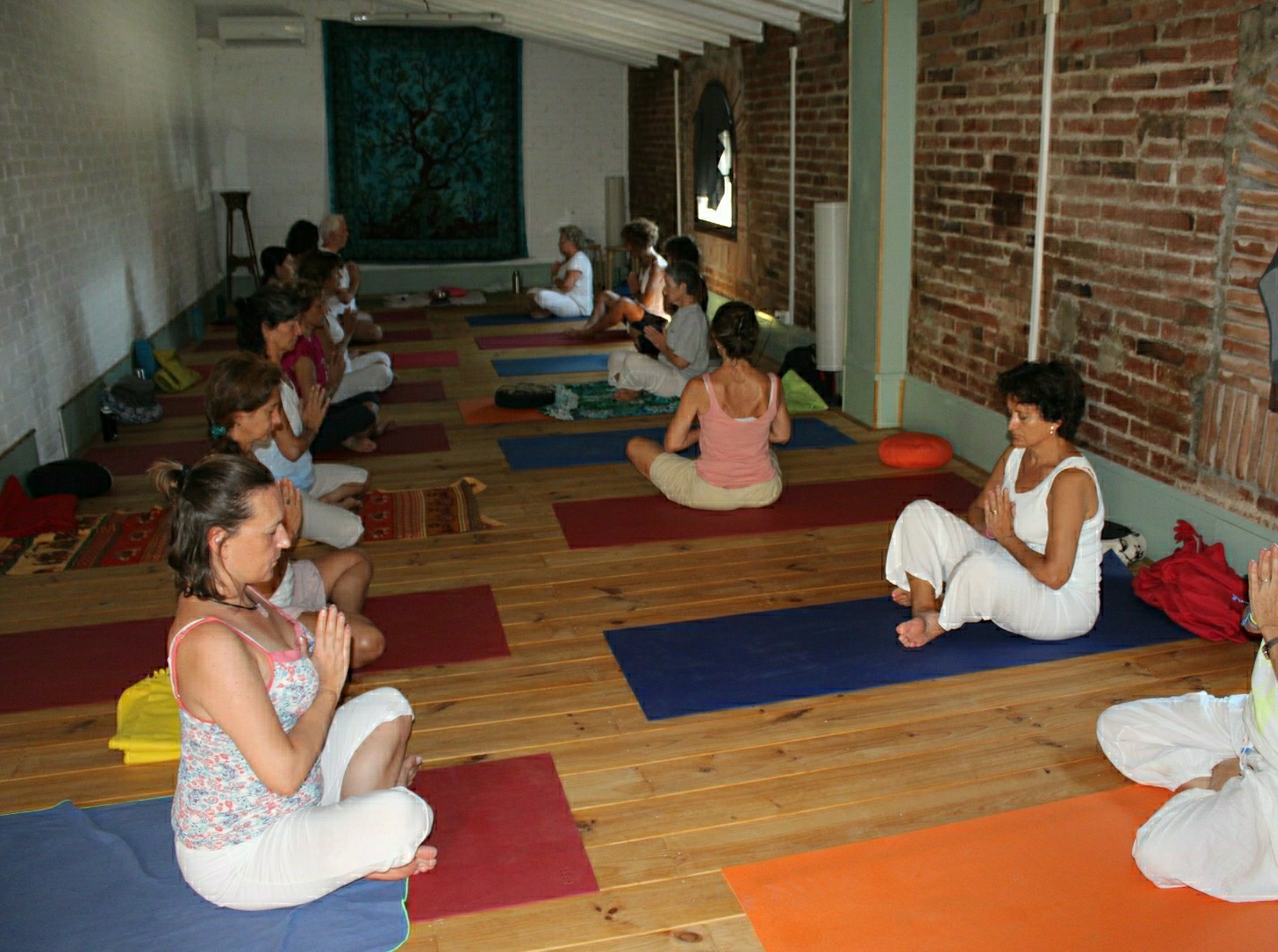 Personas meditando en clase de yoga