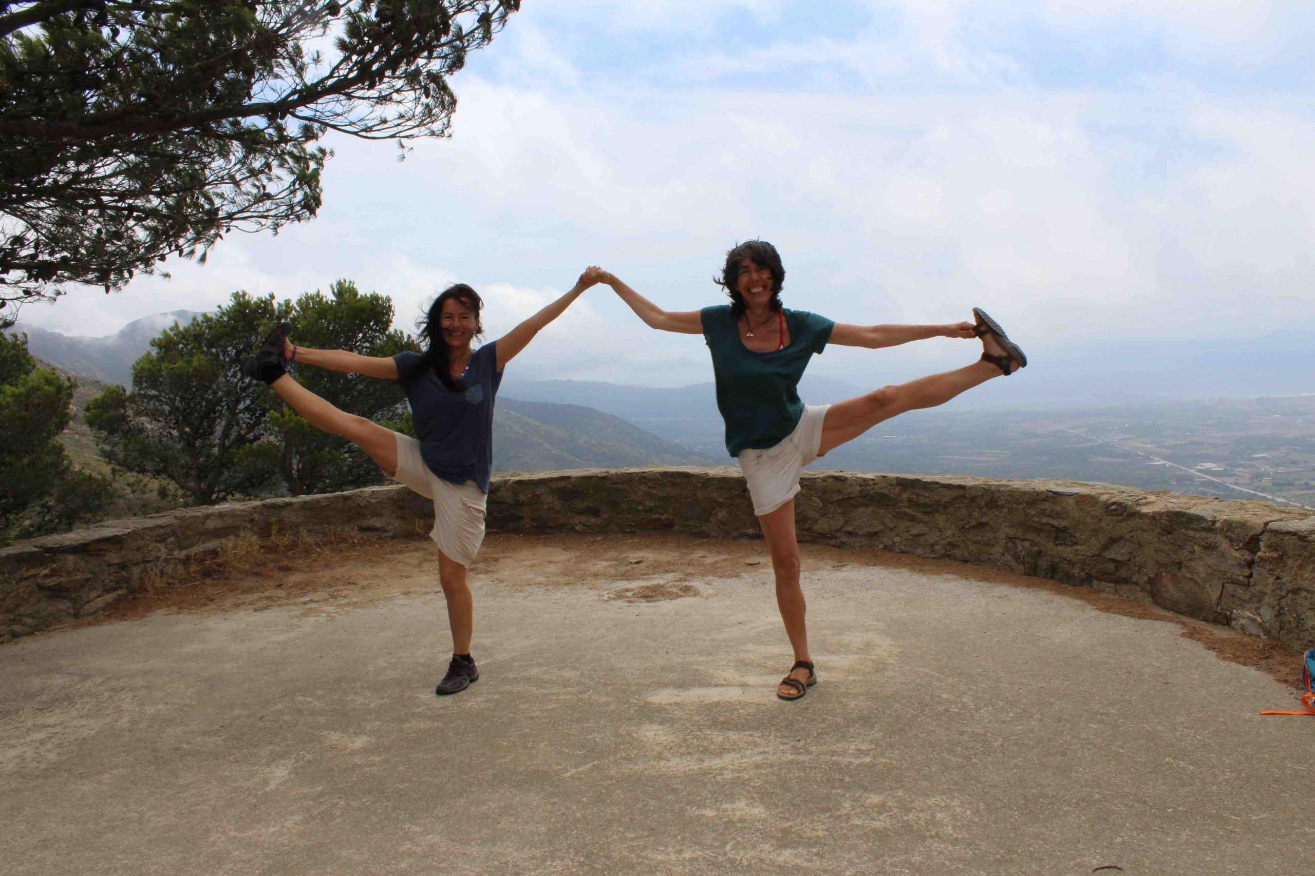 Dos profesoras de yoga en equilibrio en la naturaleza